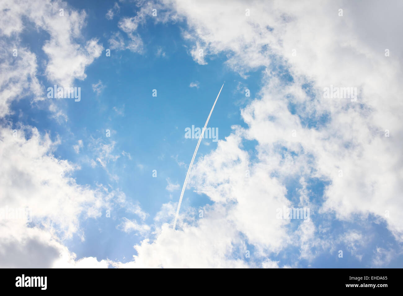 Airplane high in blue sky with clouds Stock Photo - Alamy