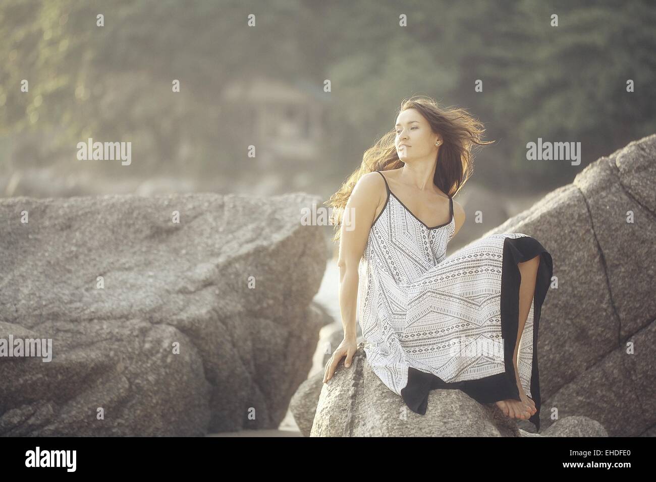 girl in a sundress summer on the rocks Model Stock Photo