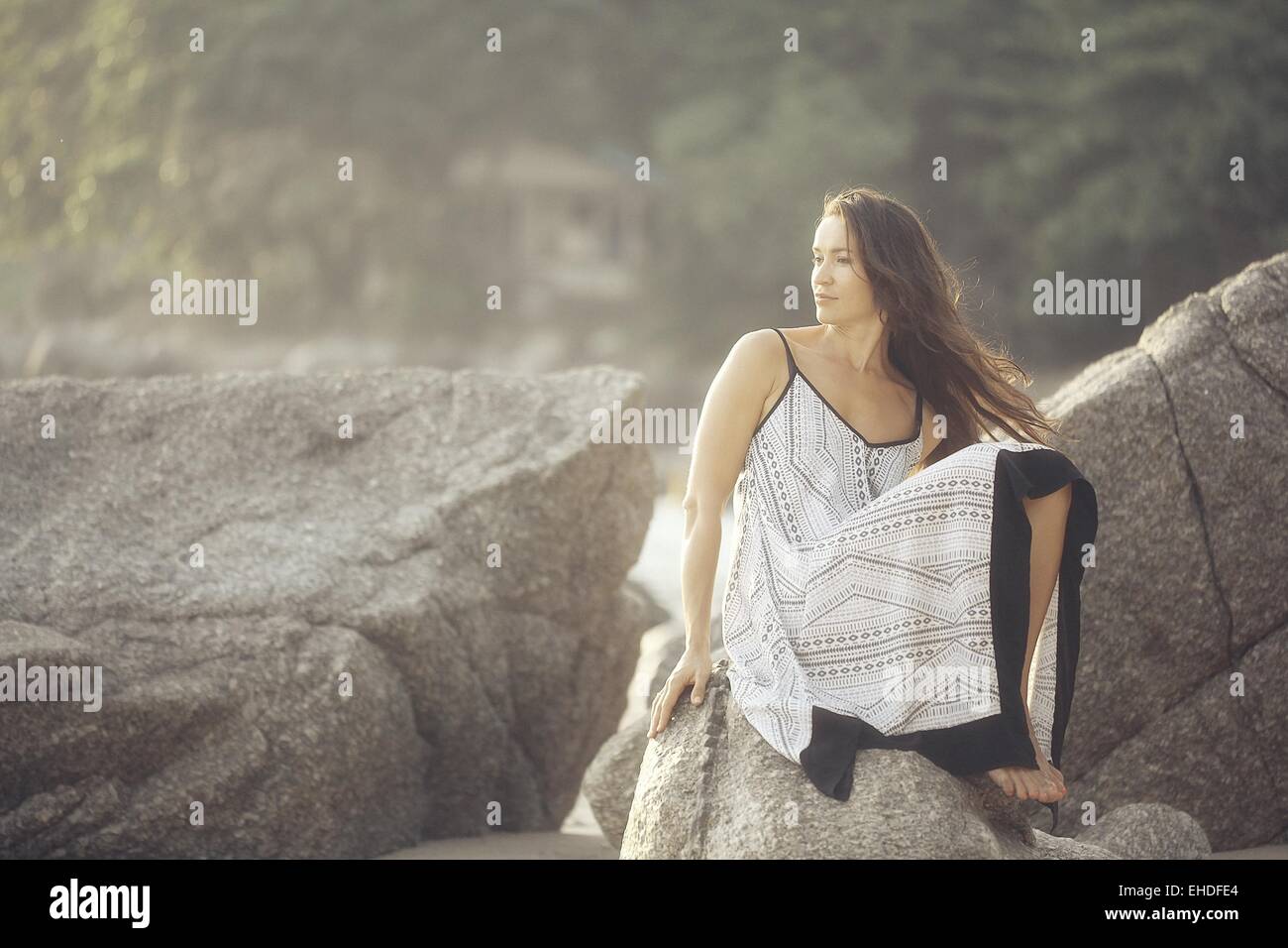 girl in a sundress summer on the rocks Model Stock Photo