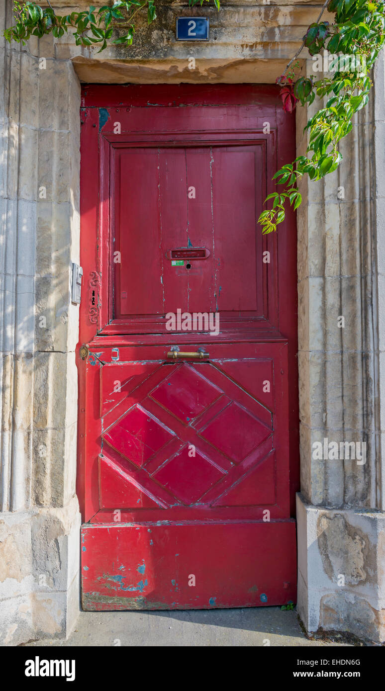 Old red wooden door with door handle in Never, France Stock Photo - Alamy