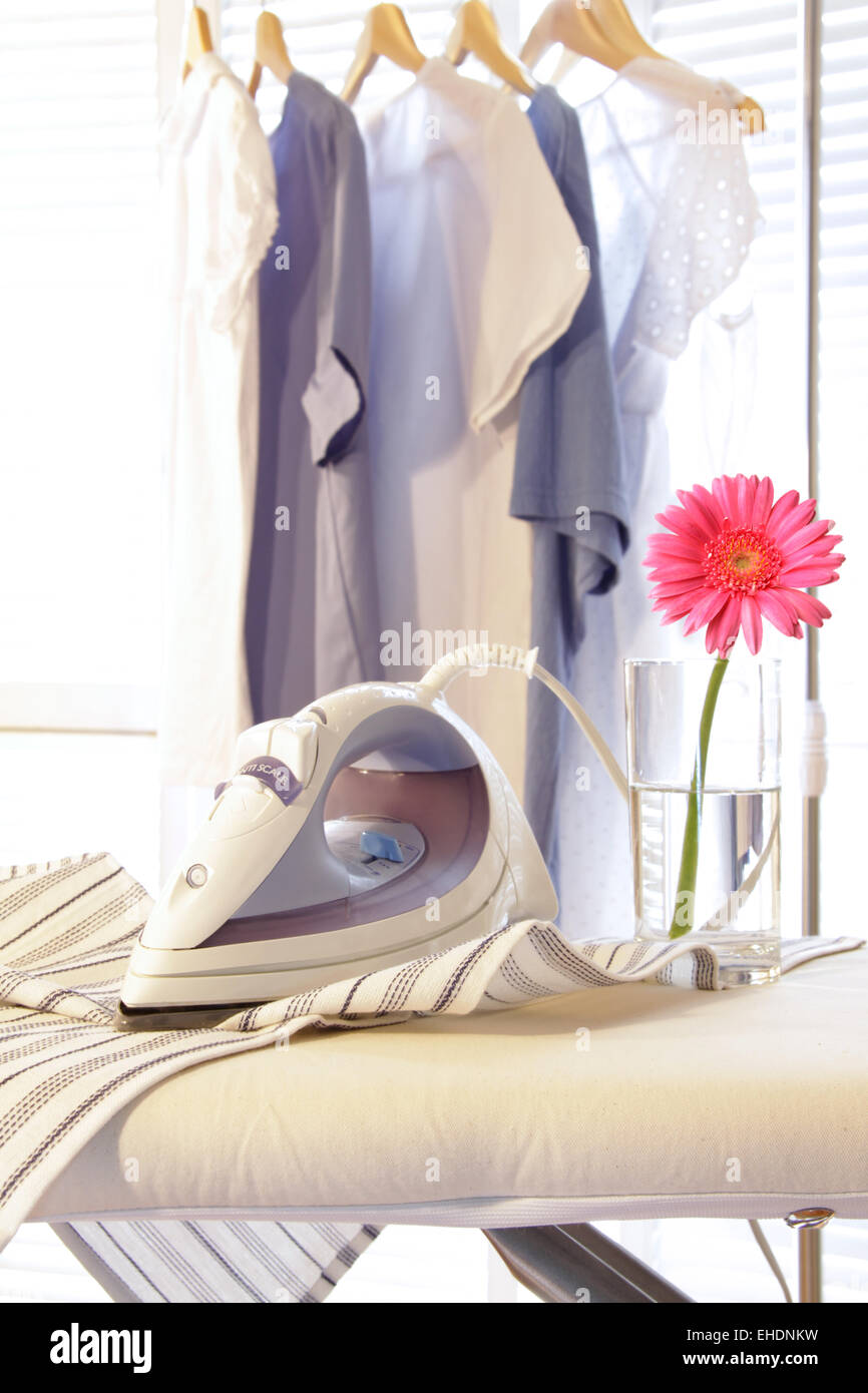 Iron on ironing board in laundry room Stock Photo Alamy