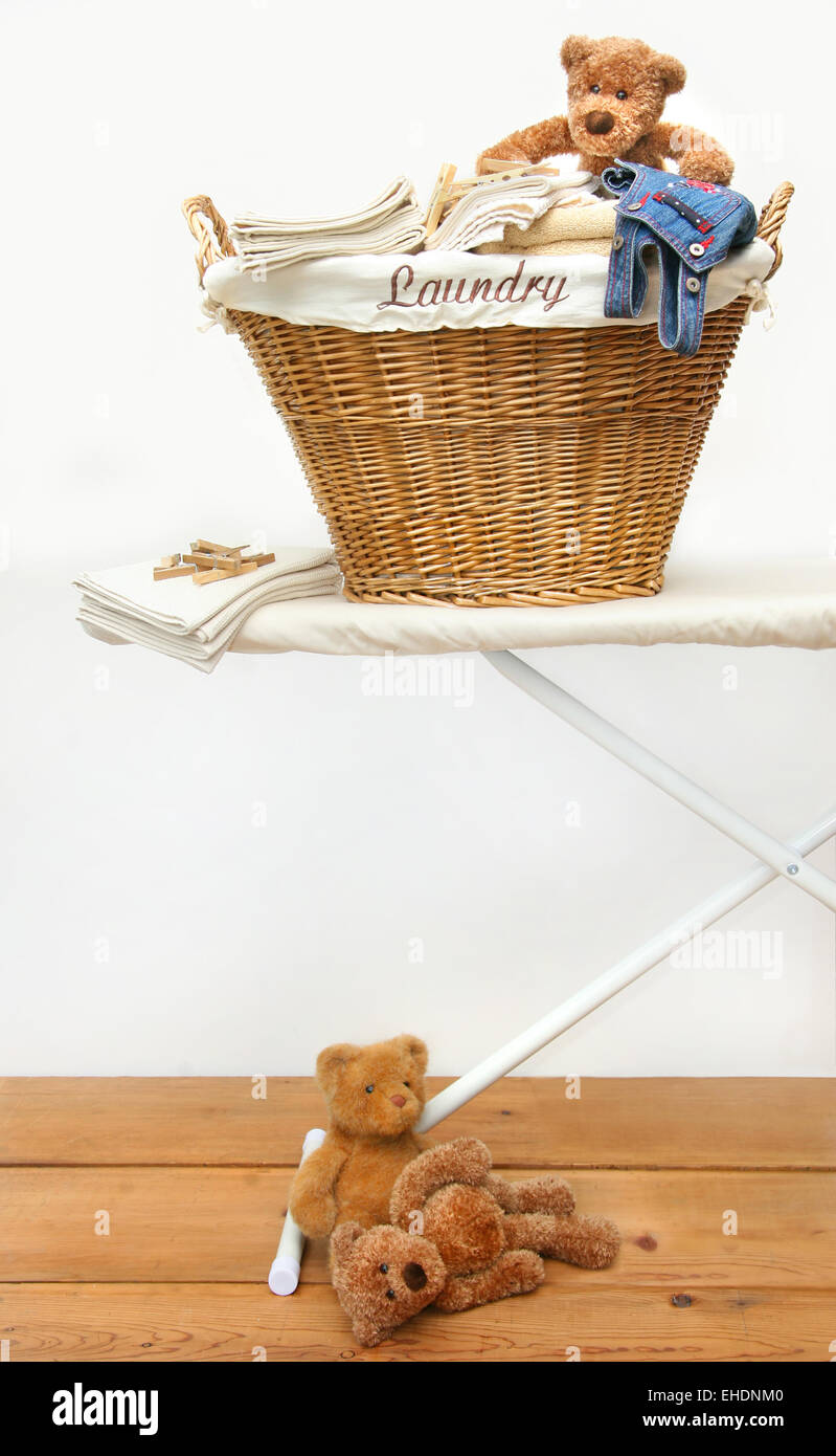 Laundry basket with teddy bears on floor Stock Photo Alamy