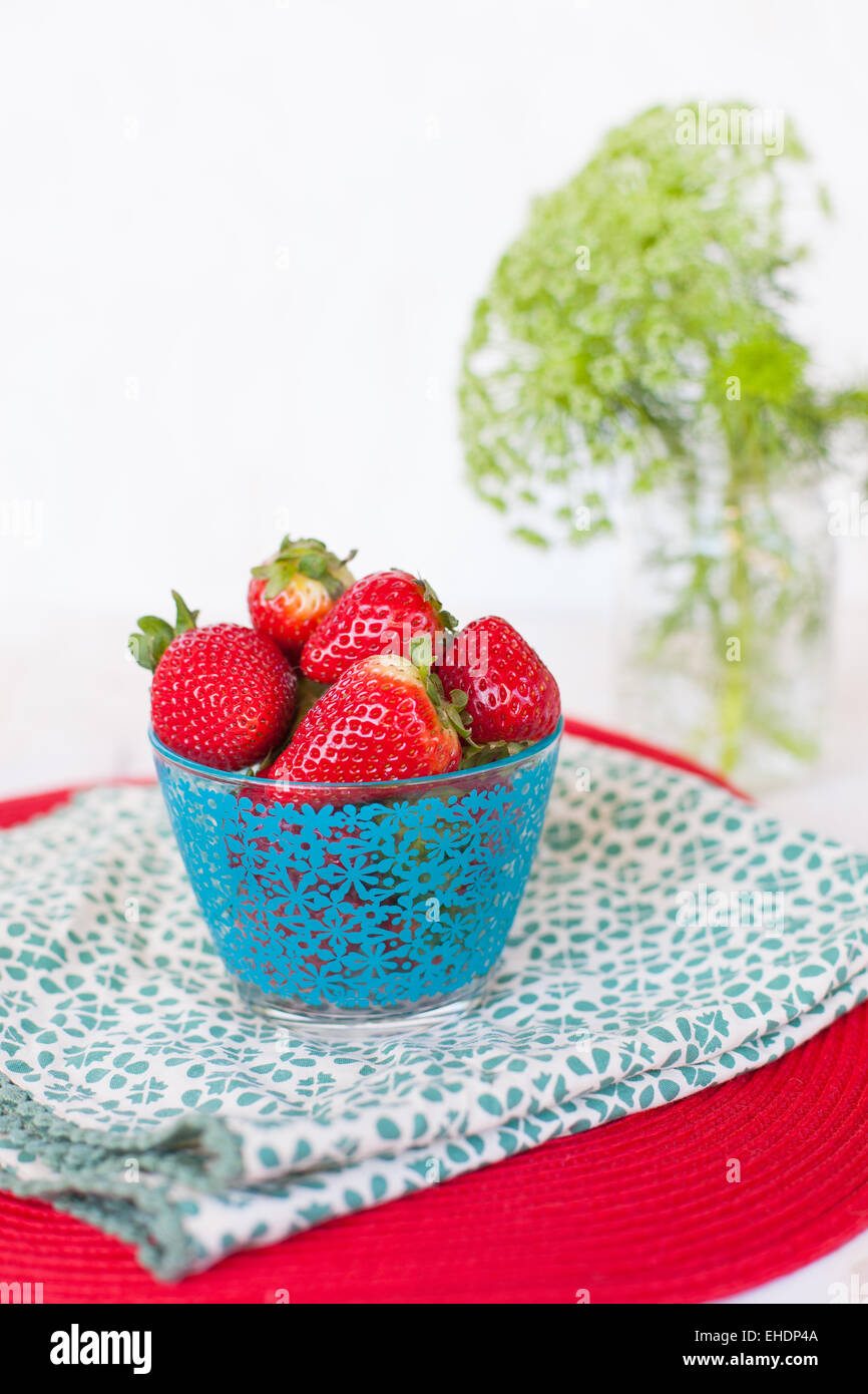 Styled bowl of fresh strawberries with flowers Stock Photo