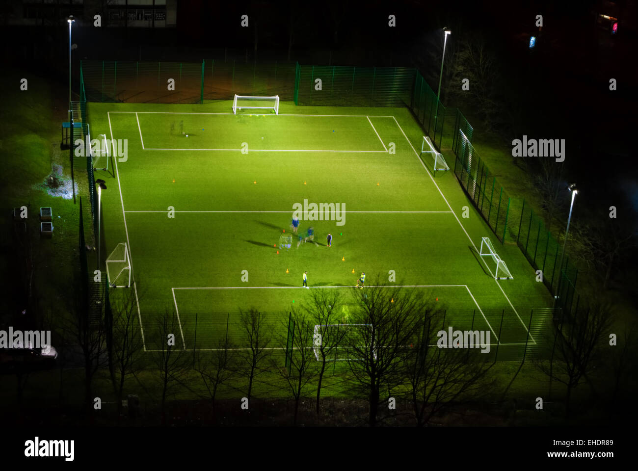 Playing football in housing scheme in Dennistoun of Glasgow at night Stock Photo