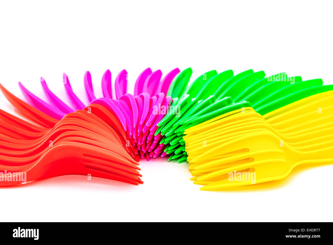 Multi colored plastic cutlery on a white background Stock Photo