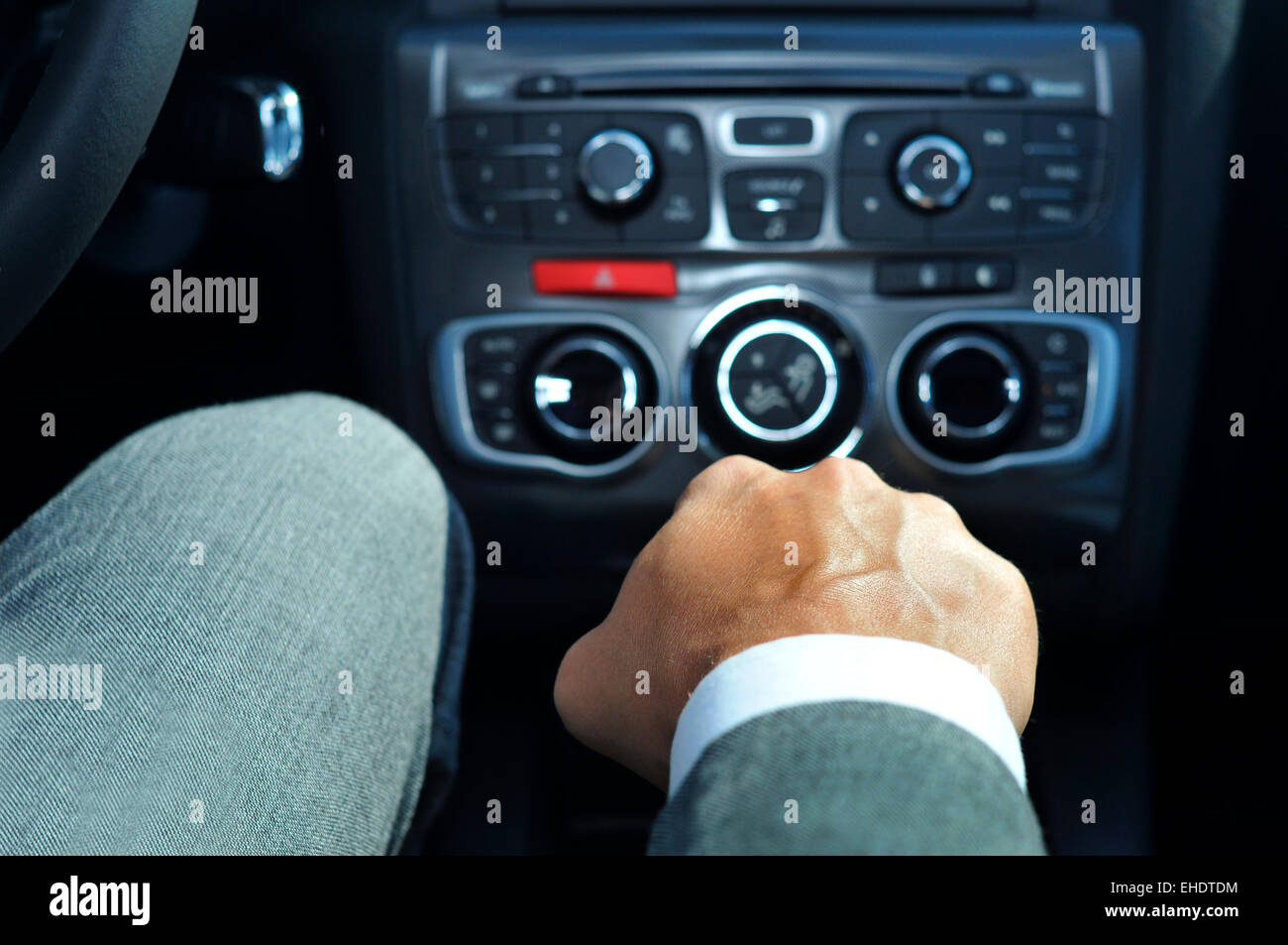 closeup of a young man in suit driving a car with manual transmission Stock Photo