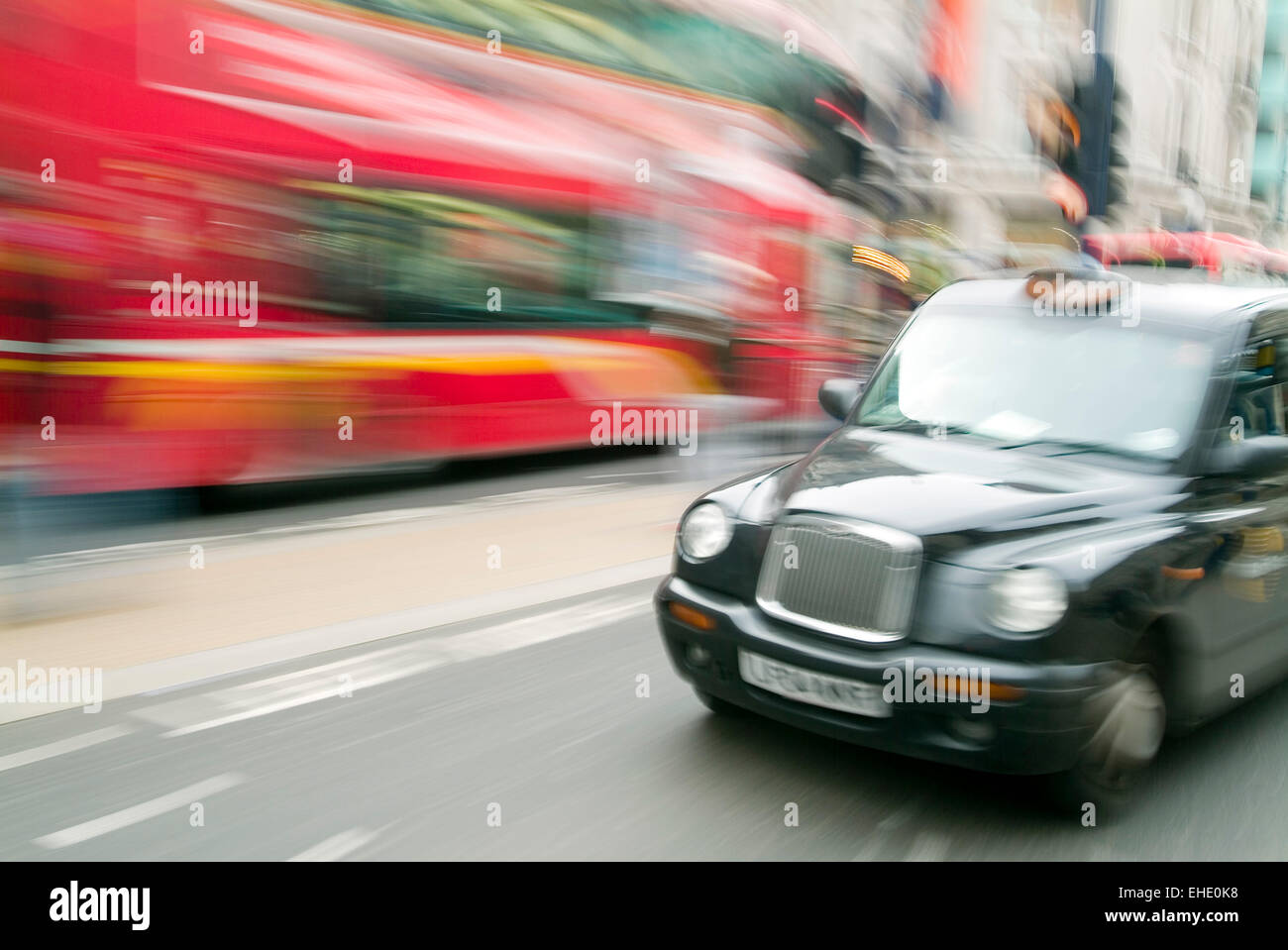 London Taxi in motion, red bus in background, London City United Kingdom GB Europe Stock Photo