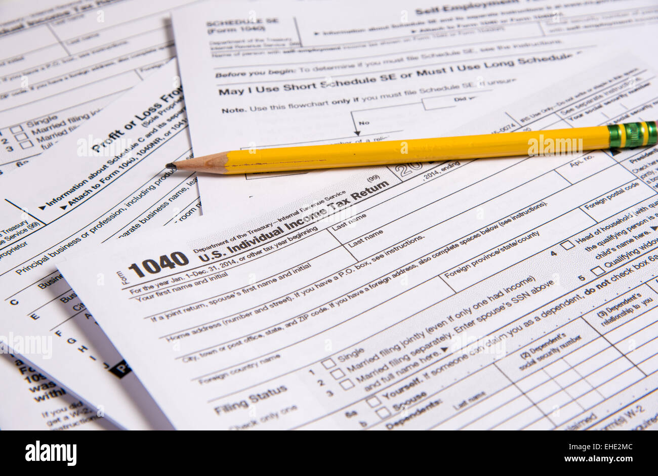 A variety of United States tax forms with a pencil Stock Photo