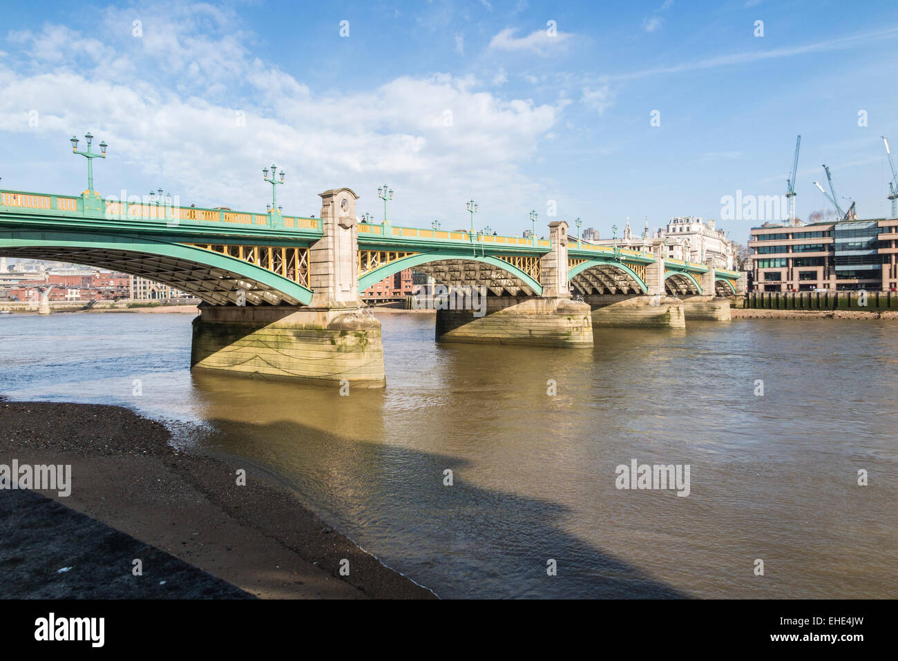 Southwark Bridge, a road bridge crossing the River Thames, London seen from the south bank on a fine, sunny day with blue sky and fluffy white clouds Stock Photo
