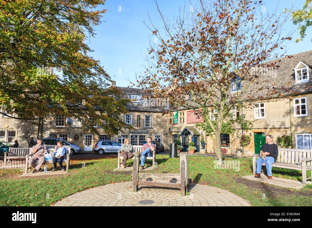 The Square, Stow-on-the-Wold, Cotswolds, Gloucestershire, with attractive Cotswold stone cottages and medieval wooden stocks Stock Photo