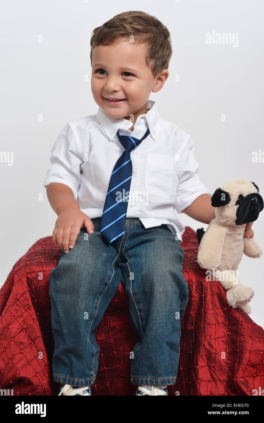 Cute two years old boy holding a stuffed animal - posing isolated in a white background. Stock Photo