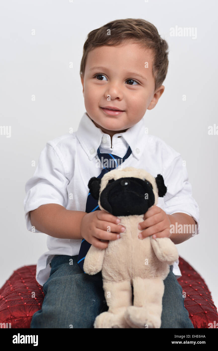 Cute two years old boy holding a stuffed animal posing isolated in a