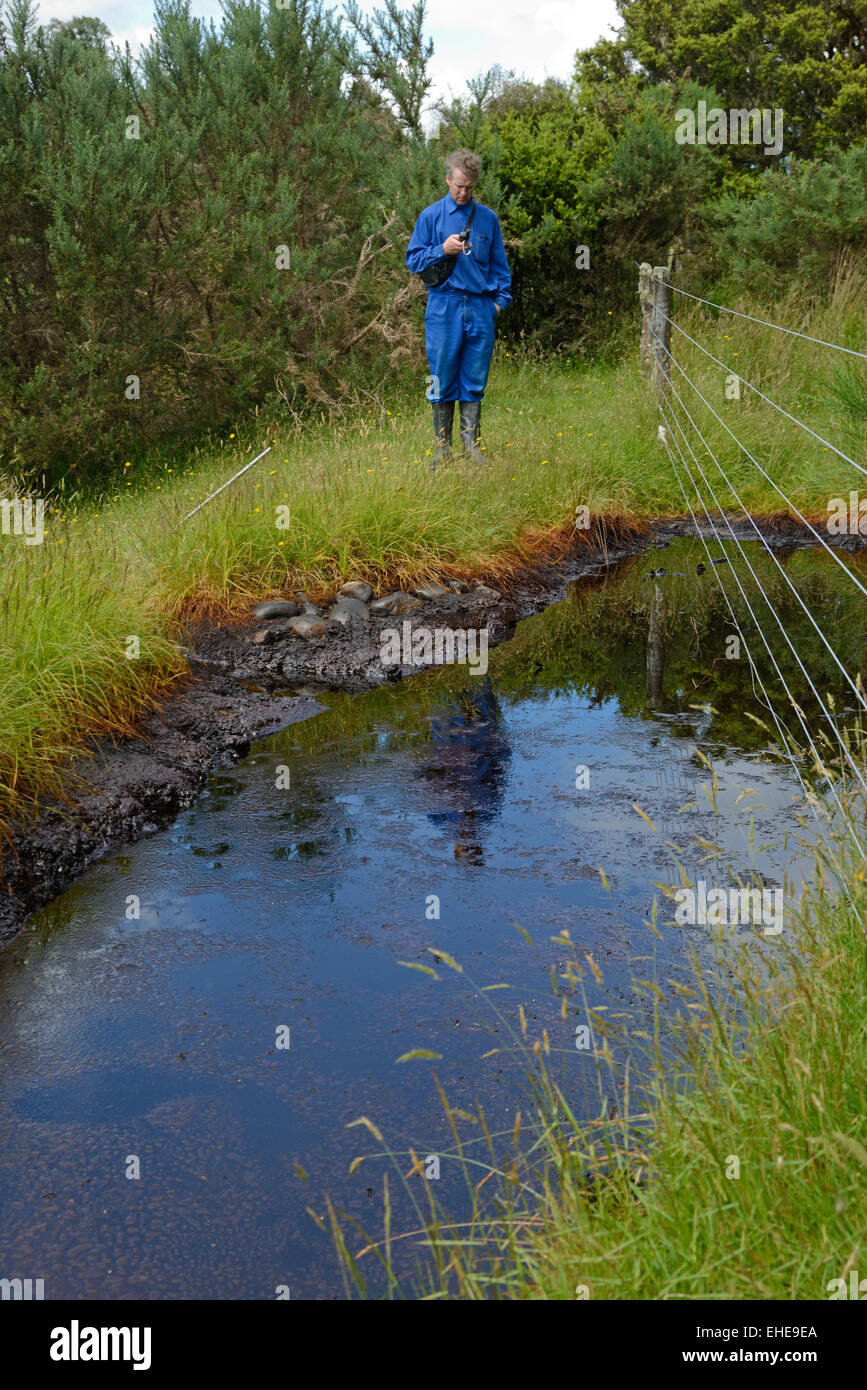 An oil prospectors take GPS readings at a natural oil seep Stock Photo