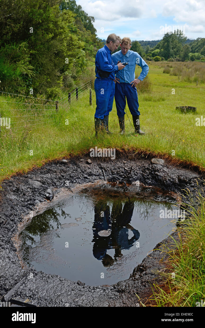 A couple of oil prospectors take GPS readings at a natural oil seep Stock Photo