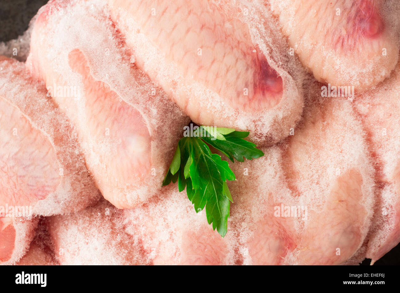 Frozen chicken wings covered with ice Stock Photo