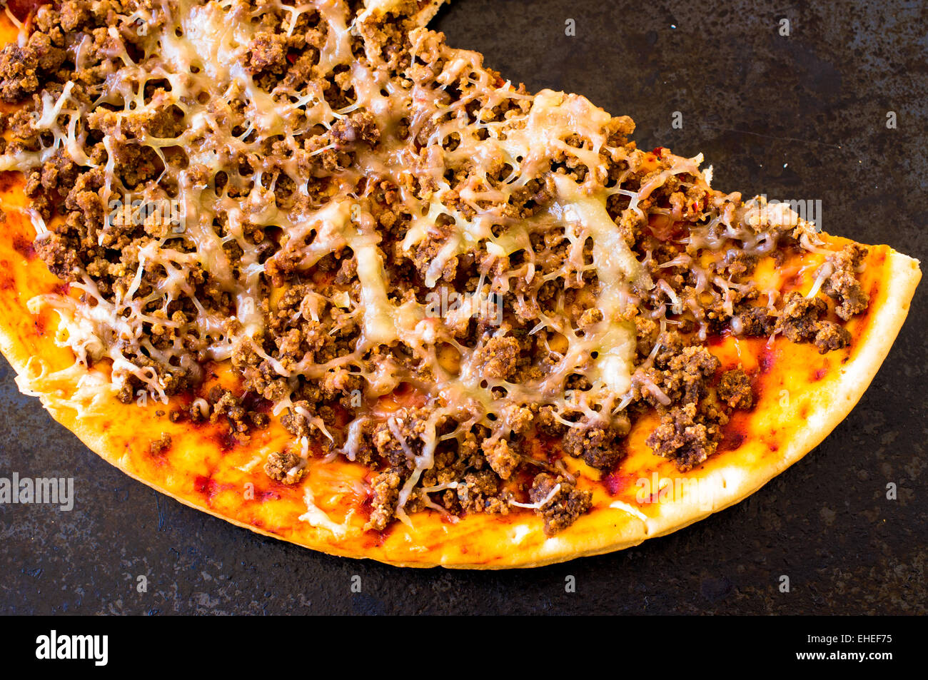 Pizza with minced meat and cheese on the stove top view Stock Photo