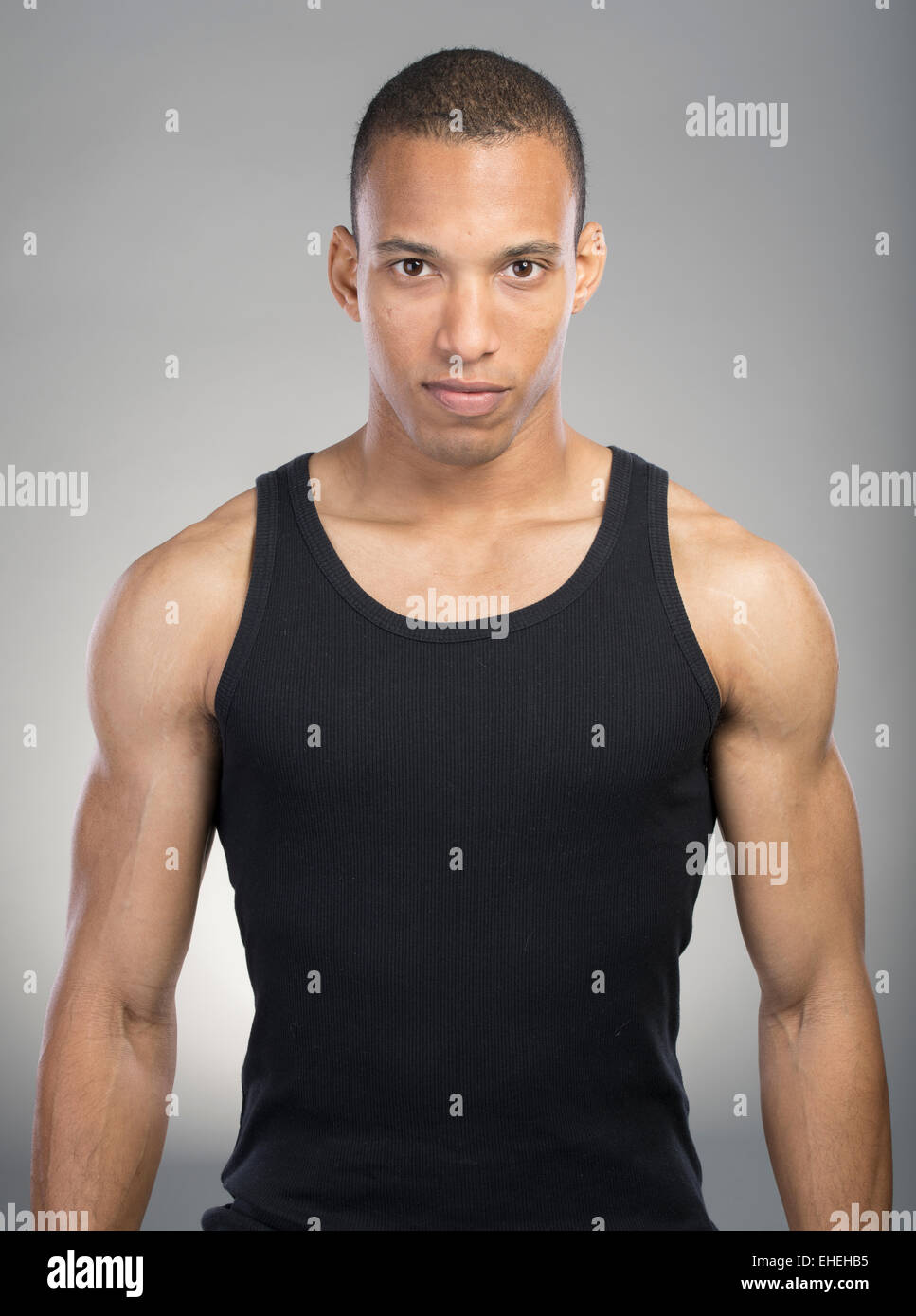 Muscular man wearing black tank top vest Stock Photo - Alamy