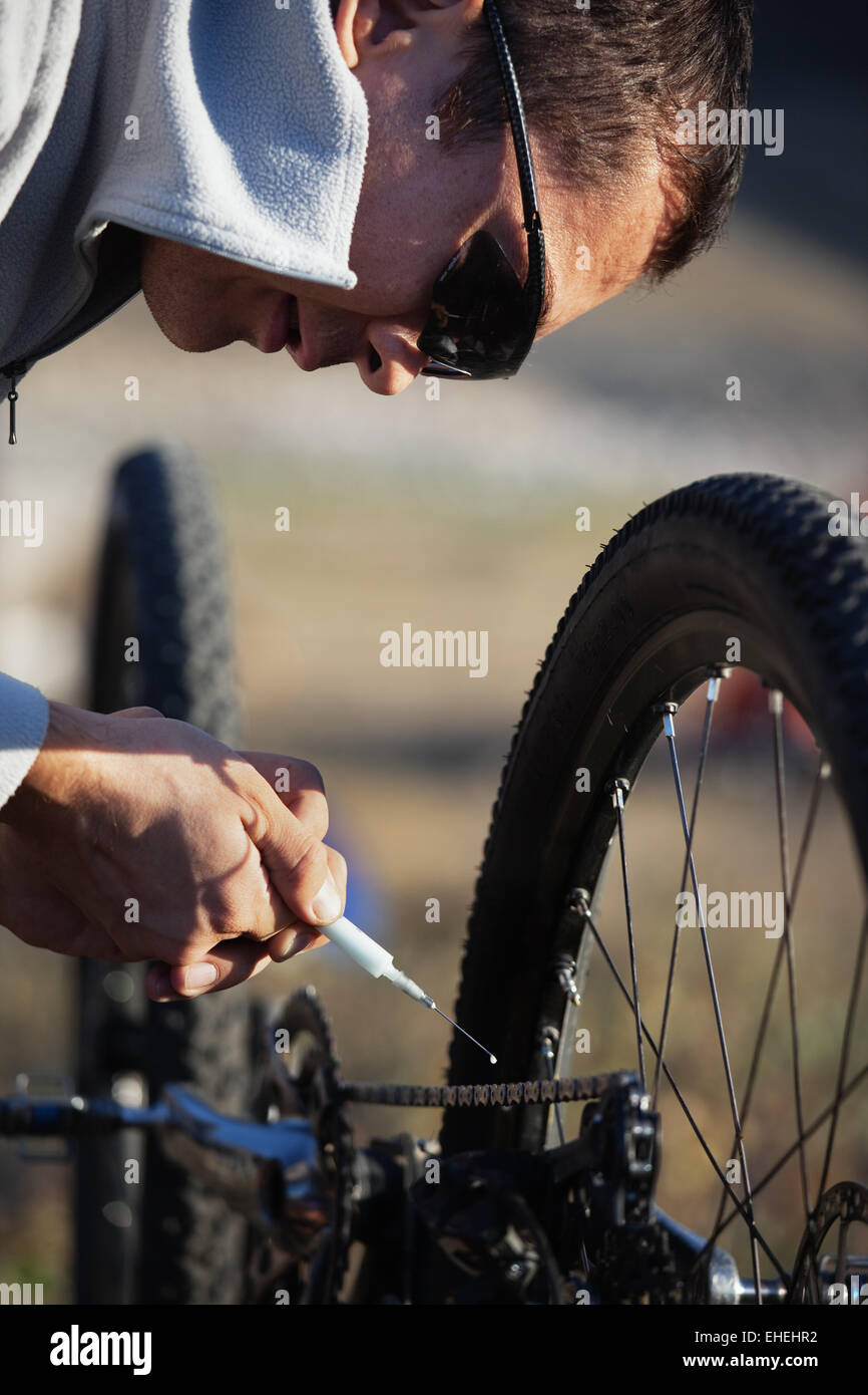 Biker lubricate bicycle chain Stock Photo
