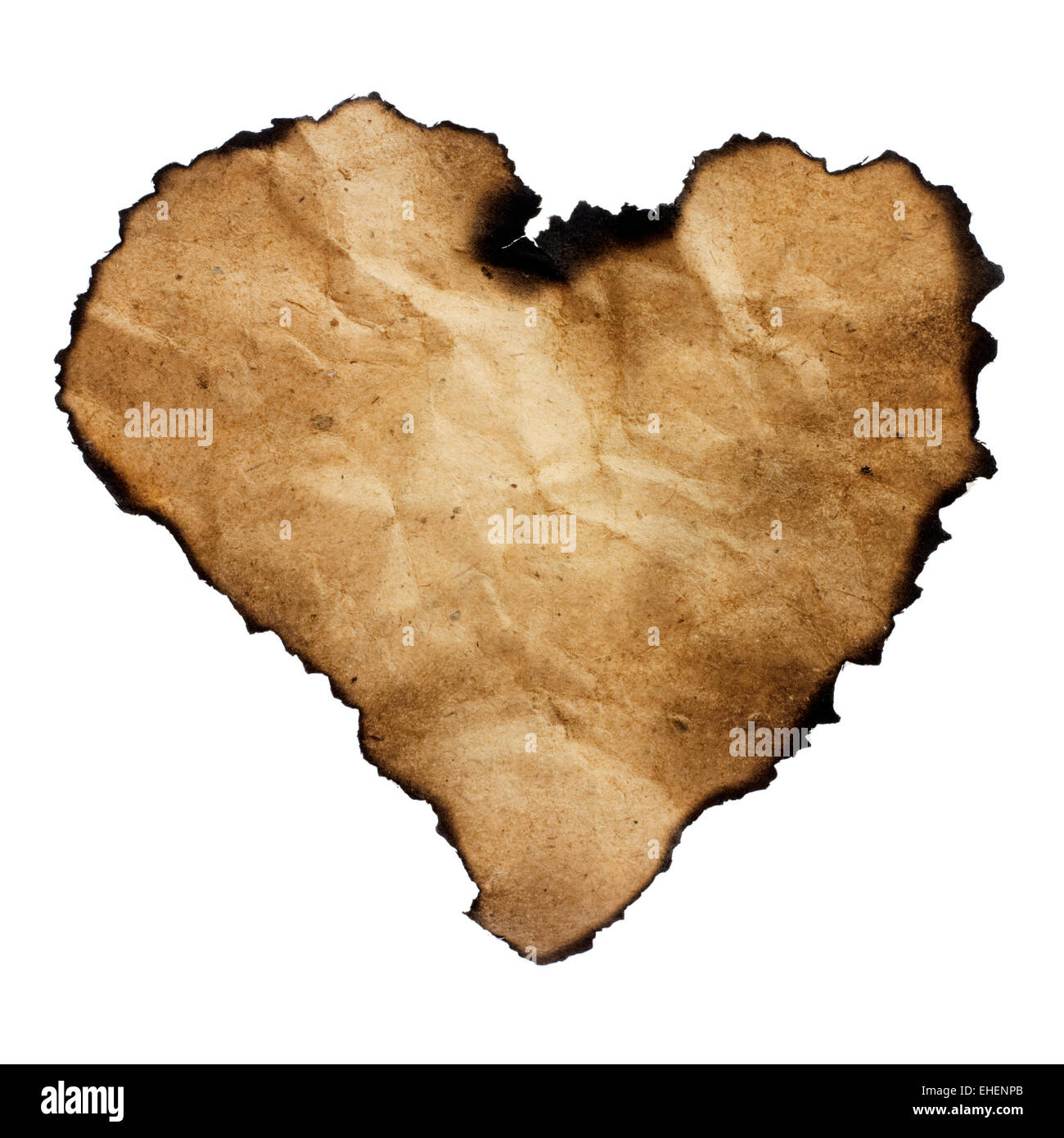 Burned heart-shaped paper isolated on white. Stock Photo