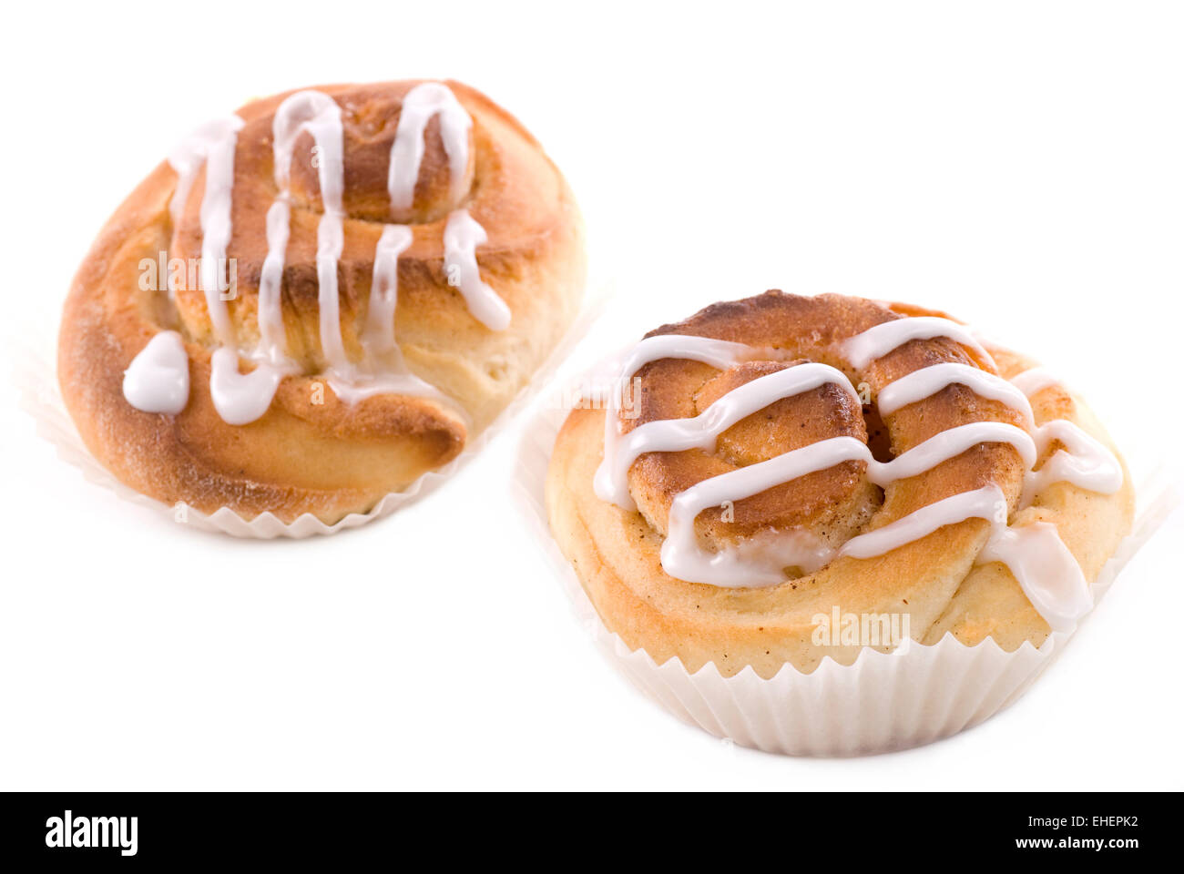Two cinnamon buns with icing on white background. Stock Photo