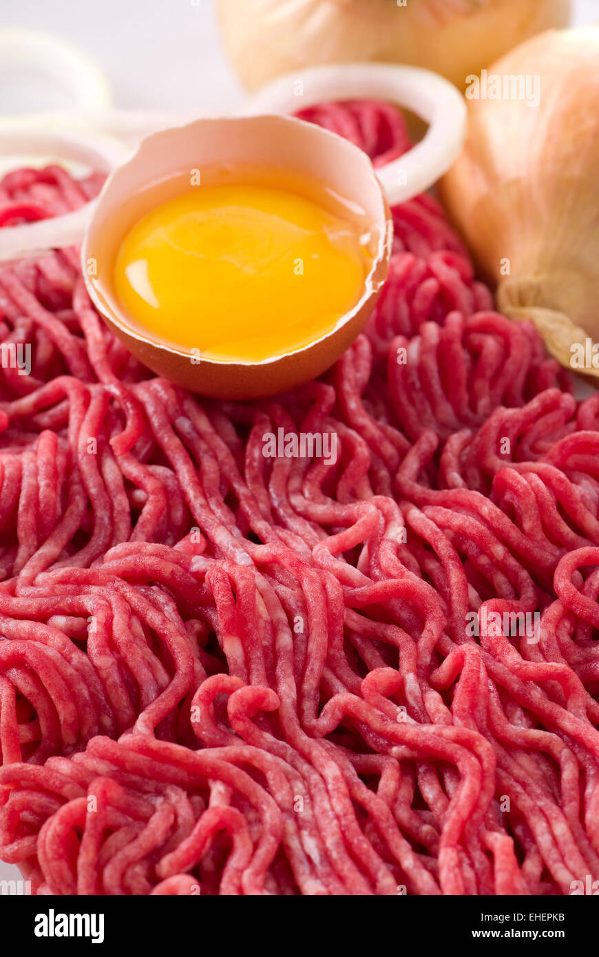 Minced meat with raw egg and onion on a plate. Stock Photo