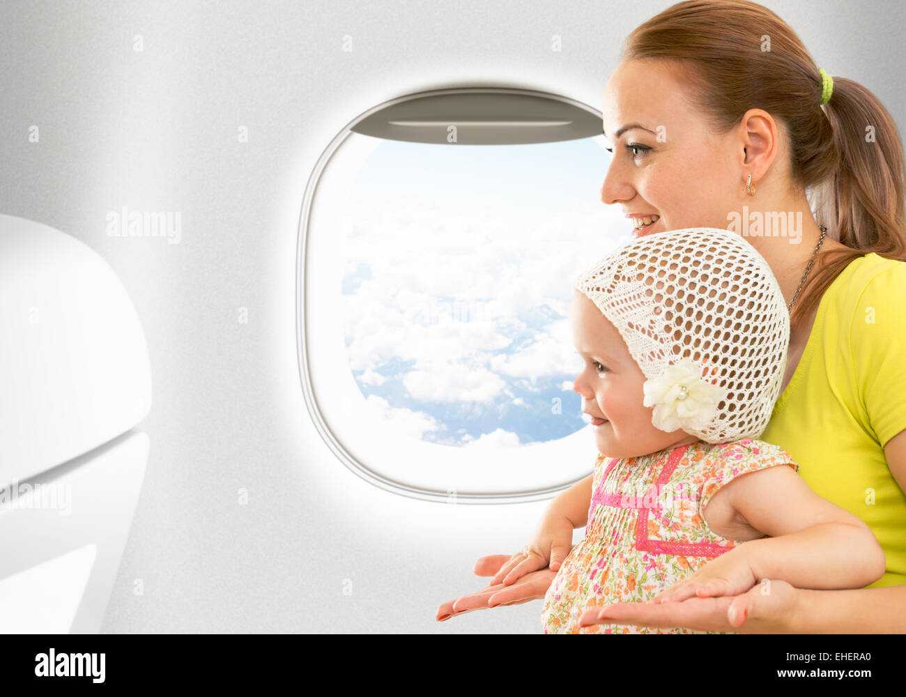 Airplane flight from inside. Woman and kid travelling together. Stock Photo