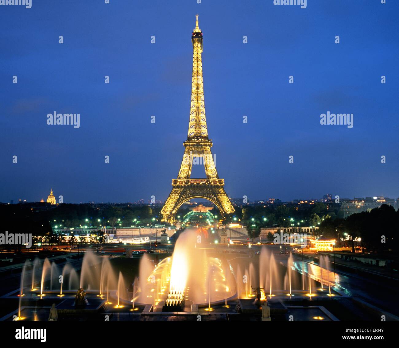Elevated view of the Eiffel Tower lit up at night with fountains in the