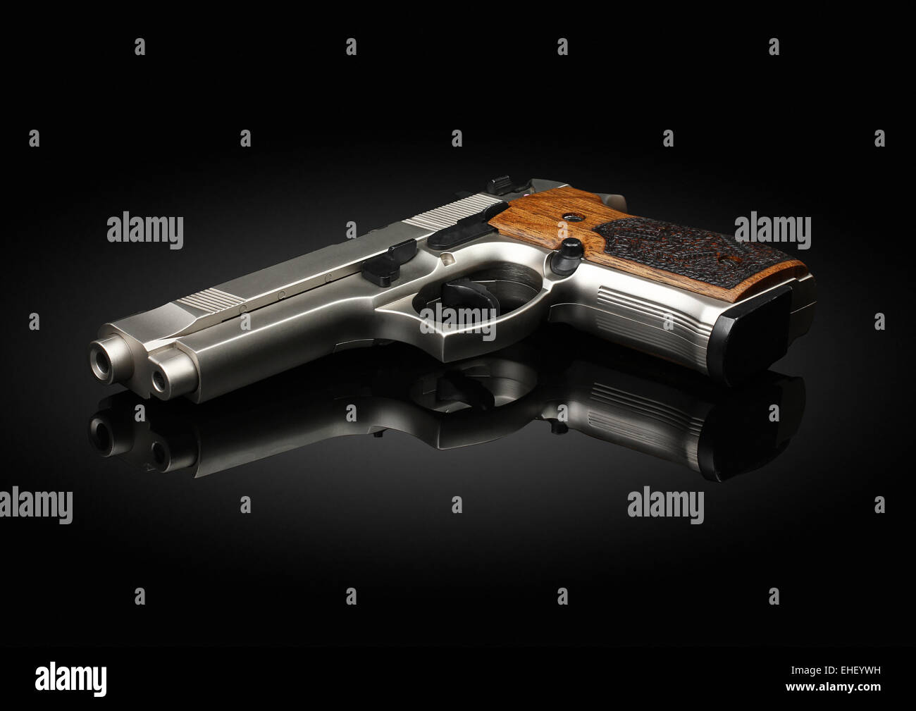 Chromed handgun on black background with reflection Stock Photo