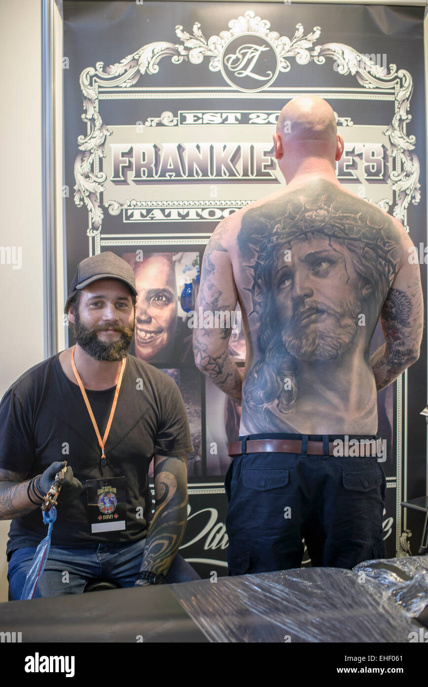 Sydney, Australia. 13th March, 2015. Sydney, AUSTRALIA - March 13, 2015:Tattoo artist from Frankie Lee's poses with an ink fan as he displays his full back tattoo of Jesus at the Australian Tattoo and Body Art Expo in Sydney. Credit:  MediaServicesAP/Alamy Live News Stock Photo