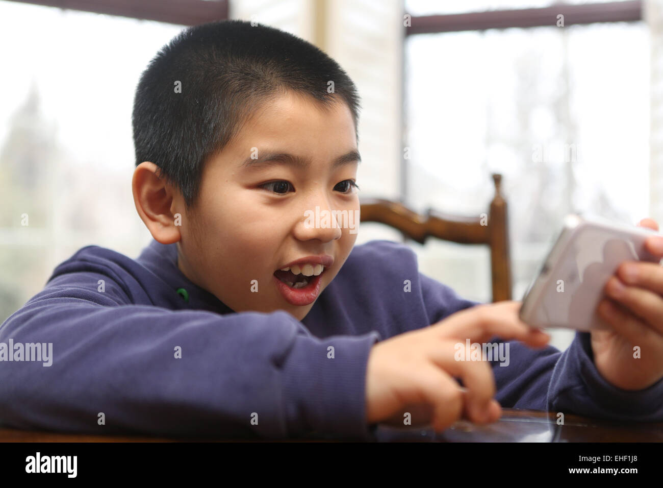 Asian Boy Playing Cell Phone Les Mains Des Enfants Tiennent Un Smart  Phonetabletcellphone Pour Jouer Et éduquer Un Enfant De 2 Ans Allongé Sur  Une Table Blanche