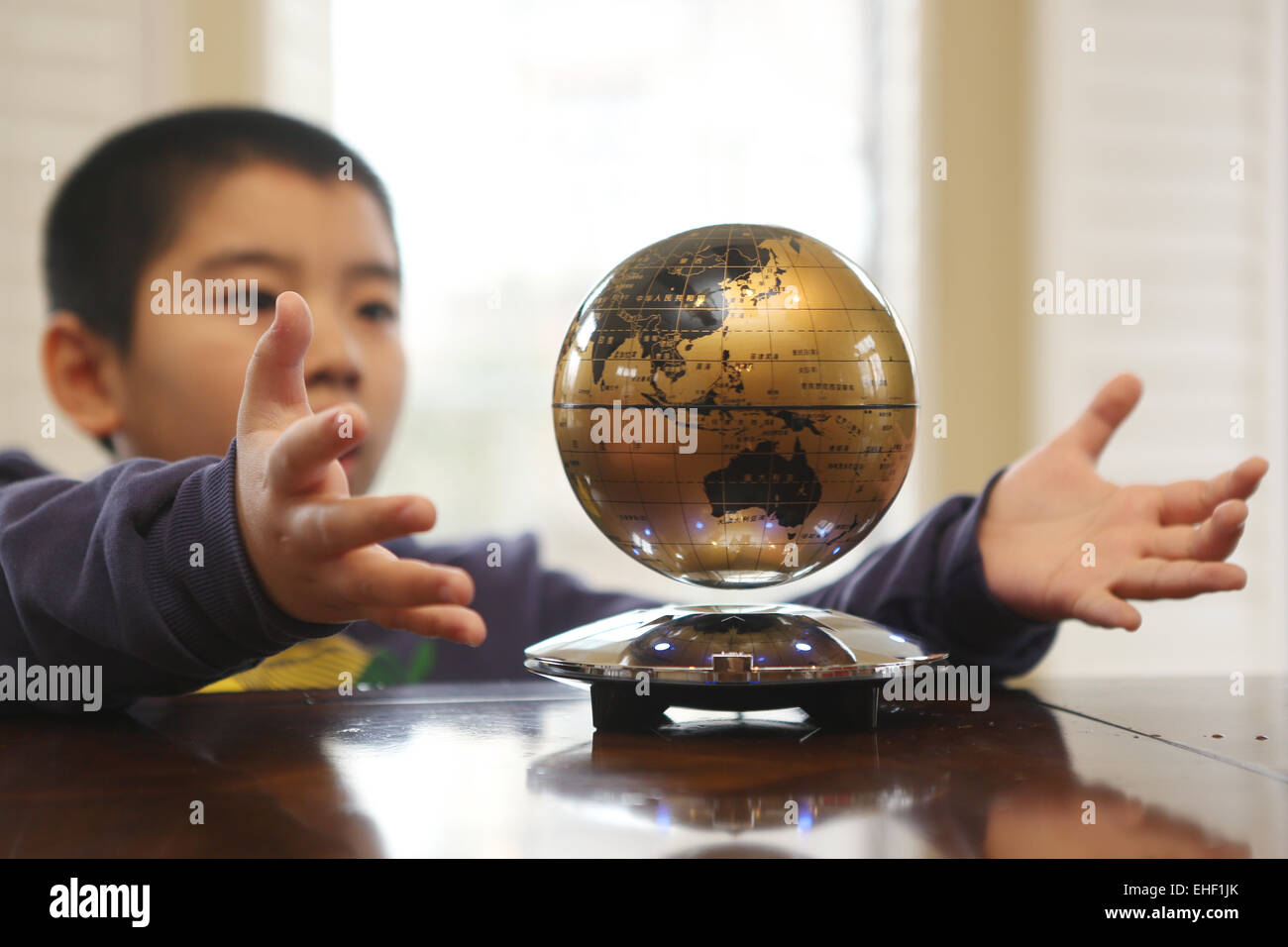 The boy stretched out his hand to hold a globe Stock Photo