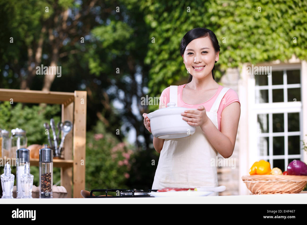 Oriental woman cooking in the outdoor kitchen Stock Photo