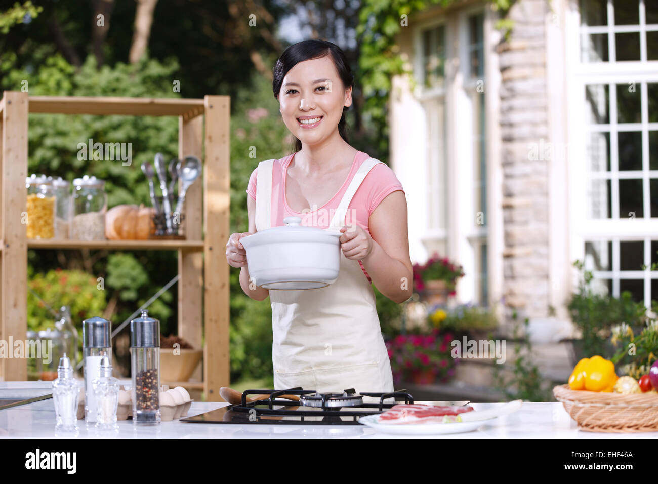 Oriental woman cooking in the outdoor kitchen Stock Photo