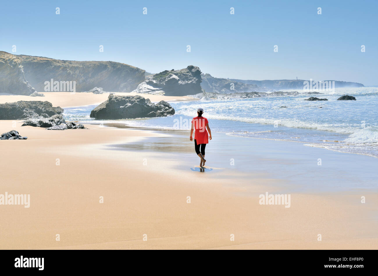 Portugal, Alentejo: Woman jogging at beach in Porto Covo Stock Photo