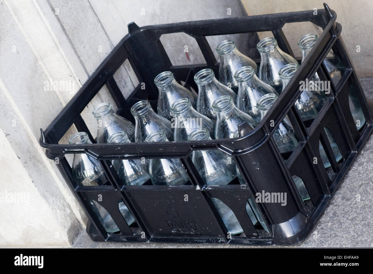 Empty traditional milk bottles in a crate on a door step Stock Photo