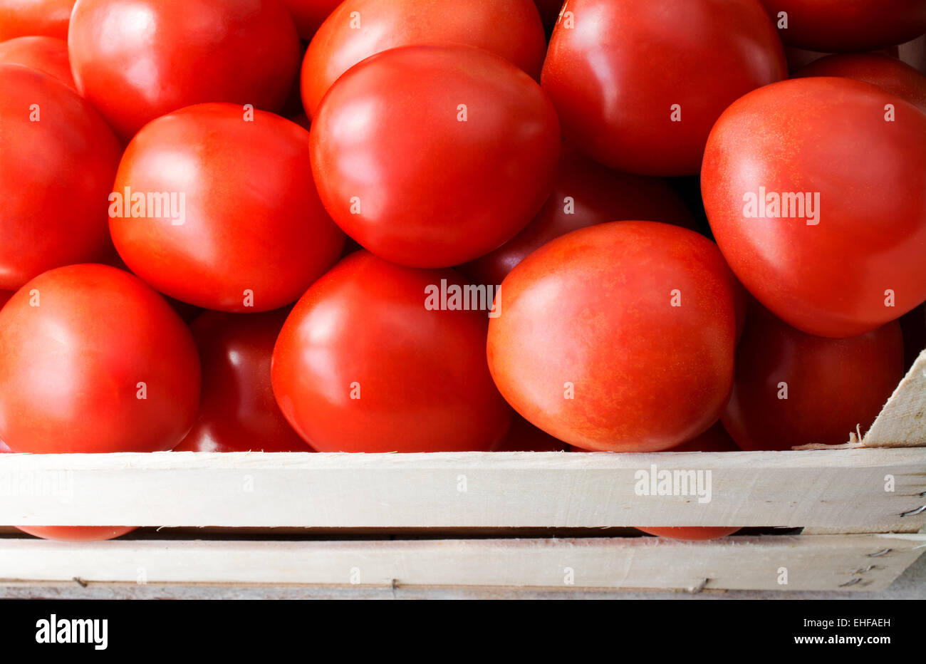 Close up shot of fresh tomatoes in a wooden crate Stock Photo