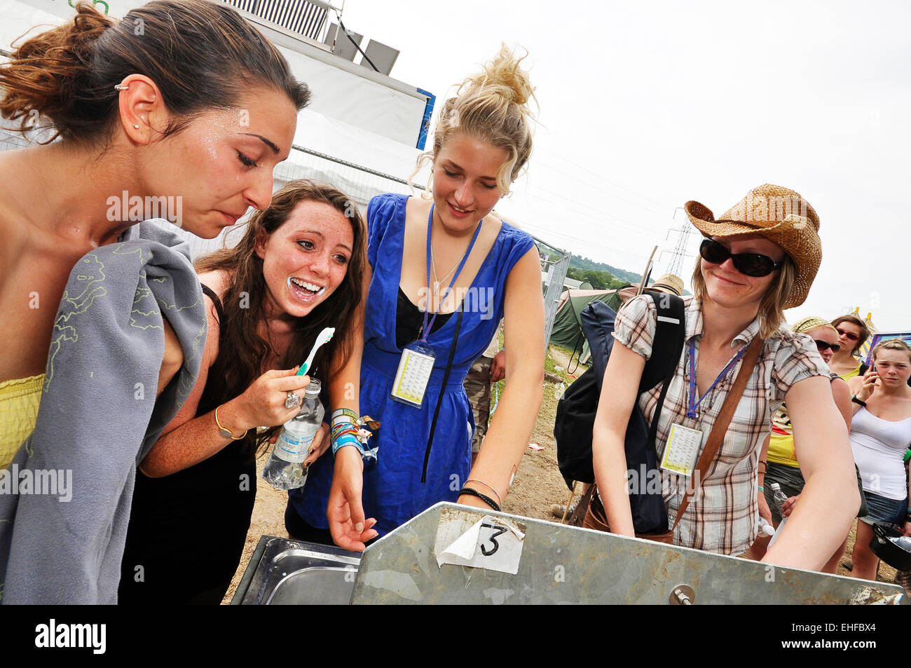 Girls washing at a sink by the toilets at Glastonbury festival, Pilton, Somerset, UK, June 2009. Stock Photo
