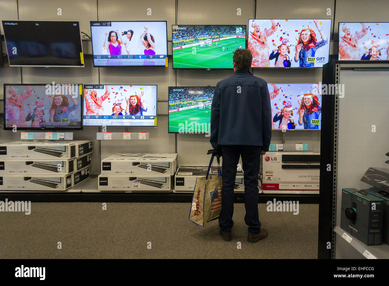 A customer browses large screen televisions in a Best Buy electronics