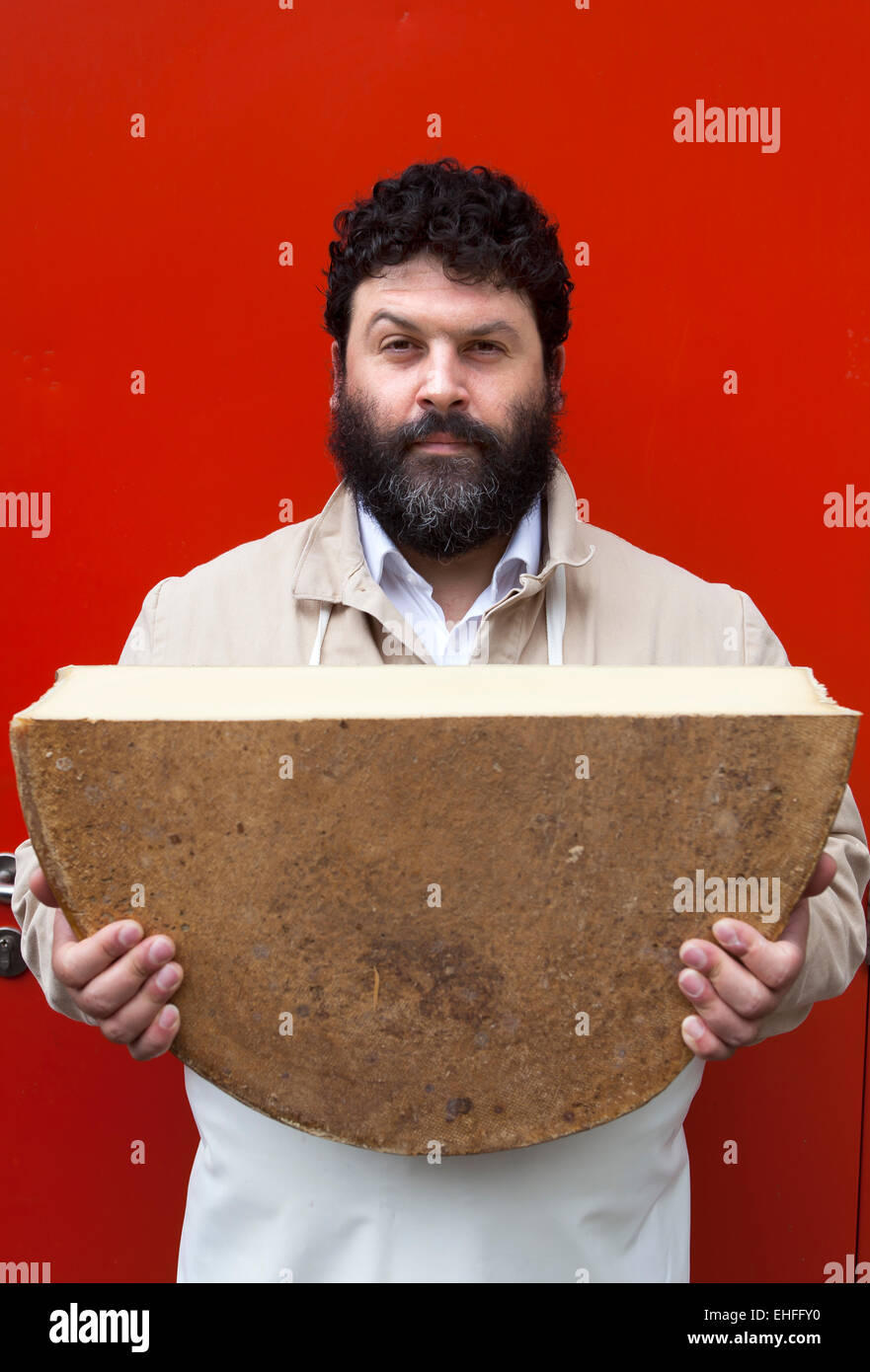 Man carrying huge block of cheese at Mons Cheesemongers London Stock