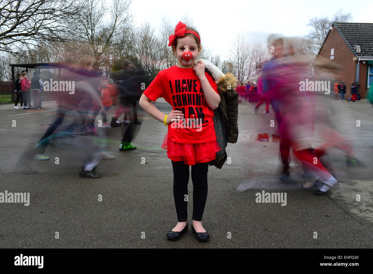 School girl Evie Carter (7) is shown dressed in red for Comic Relief's 2015 Red Nose Day. Stock Photo