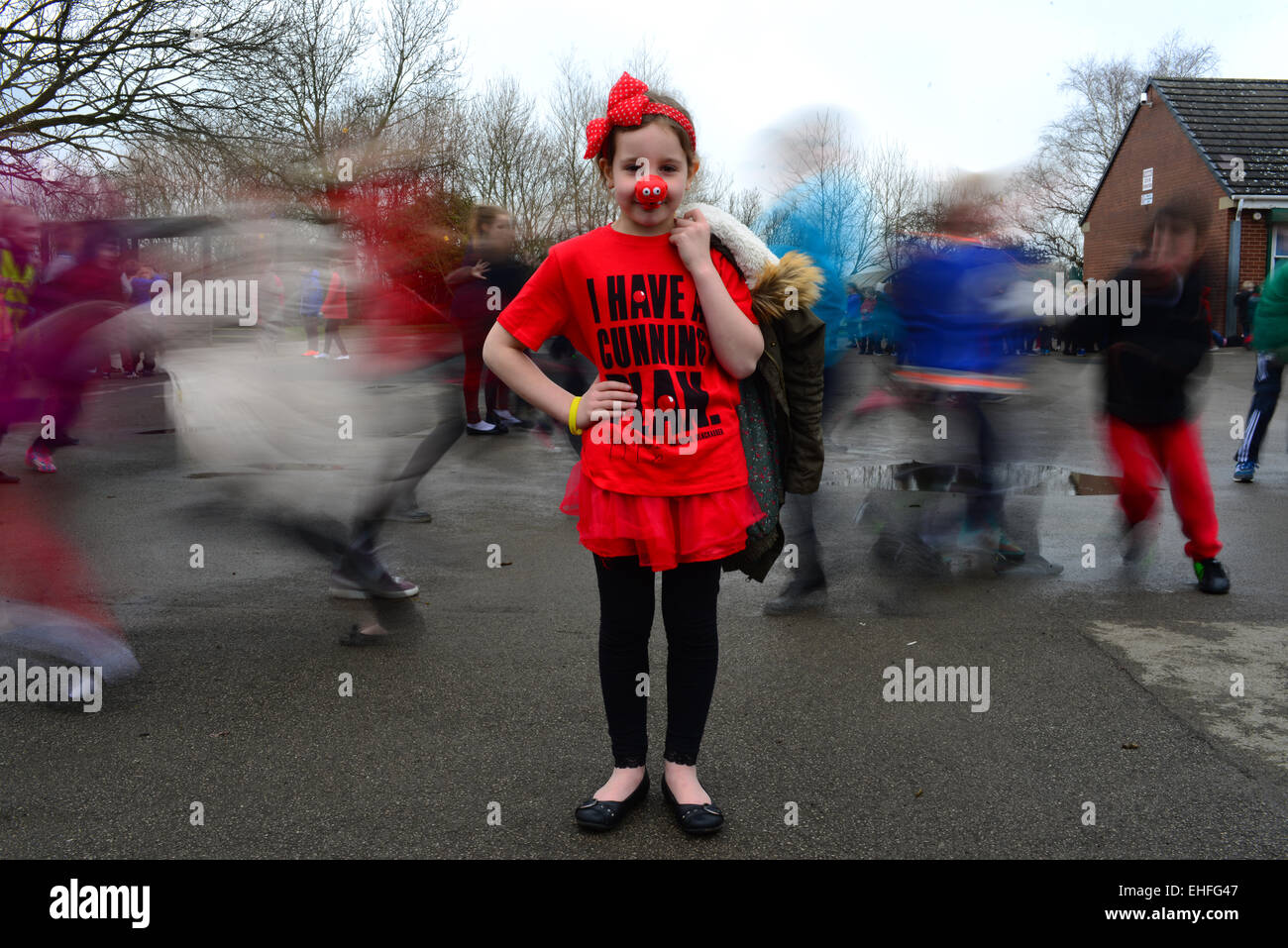 School girl Evie Carter (7) is shown dressed in red for Comic Relief's 2015 Red Nose Day. Stock Photo