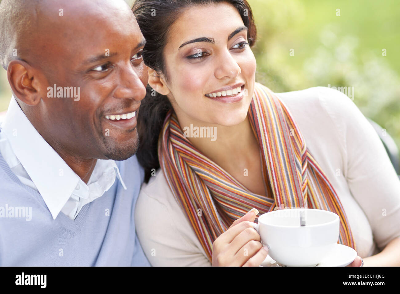 Couple relaxing outdoors drinking coffee Stock Photo
