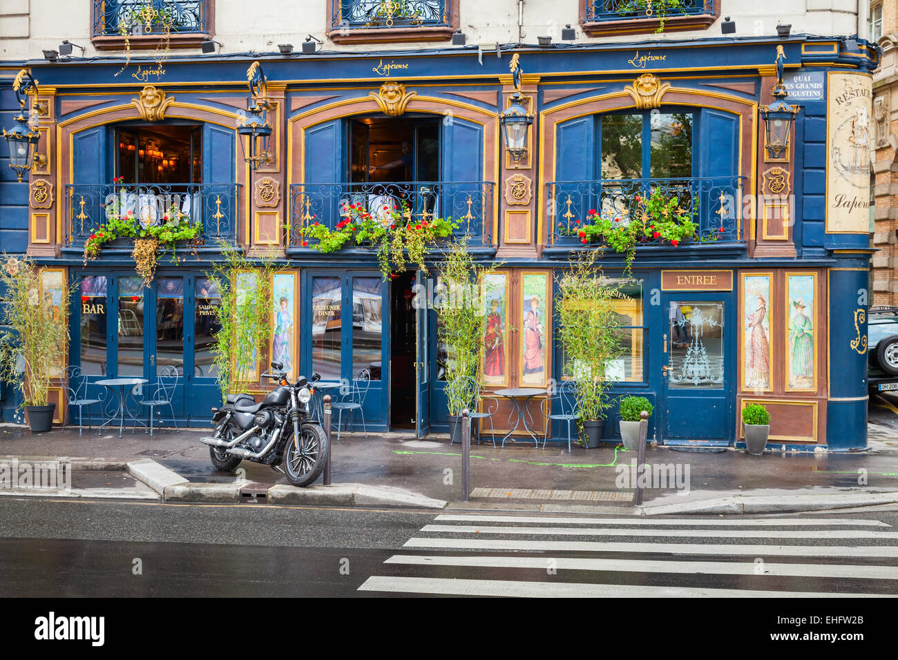 Paris, France - August 07, 2014: Black motorcycle stands parked near blue bar facade on the Quai Des Grands Augustins Stock Photo