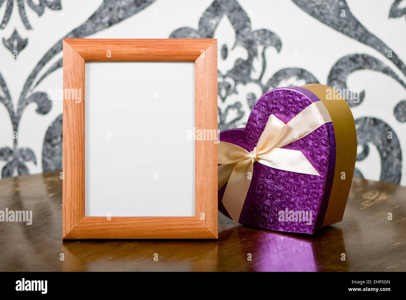 Wooden photo frame and present box on table Stock Photo
