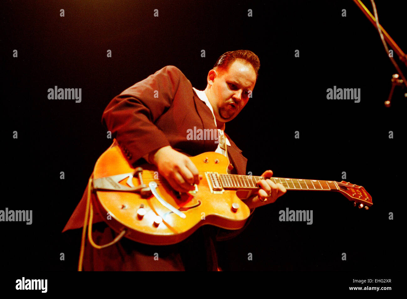 Big man playing rock n roll guitar. Stock Photo