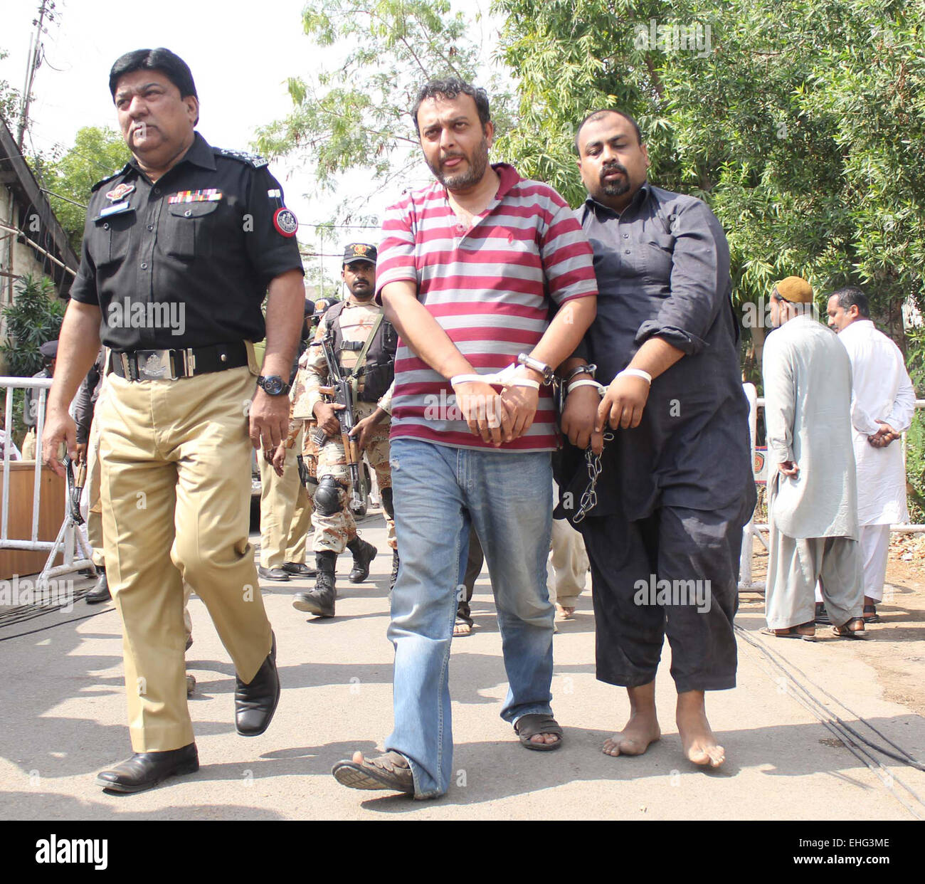 Proclaimed offenders Kamran alias Zeeshan and Faisal Mota were sentenced to death in journalist Wali Khan Babar murder case and recovered during Rangers raid on Wednesday at MQM headquarter Nine-Zero being escorting by security staffs and presented to Anti Terrorist Court of Karachi on Friday, March 13, 2015. Stock Photo