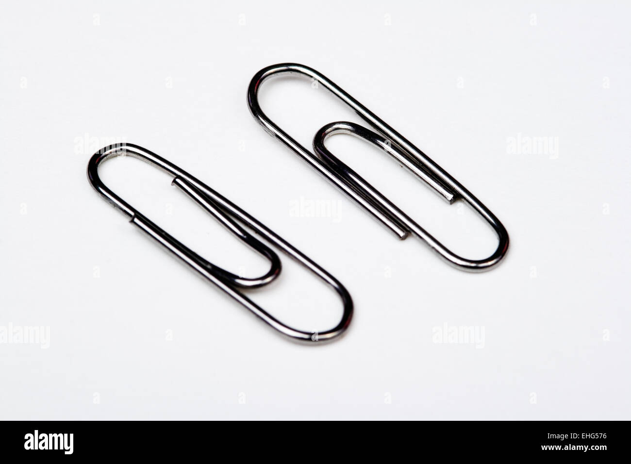 Muchos clips de metal sobre fondo blanco - A lot of metal paperclips on a white background Stock Photo