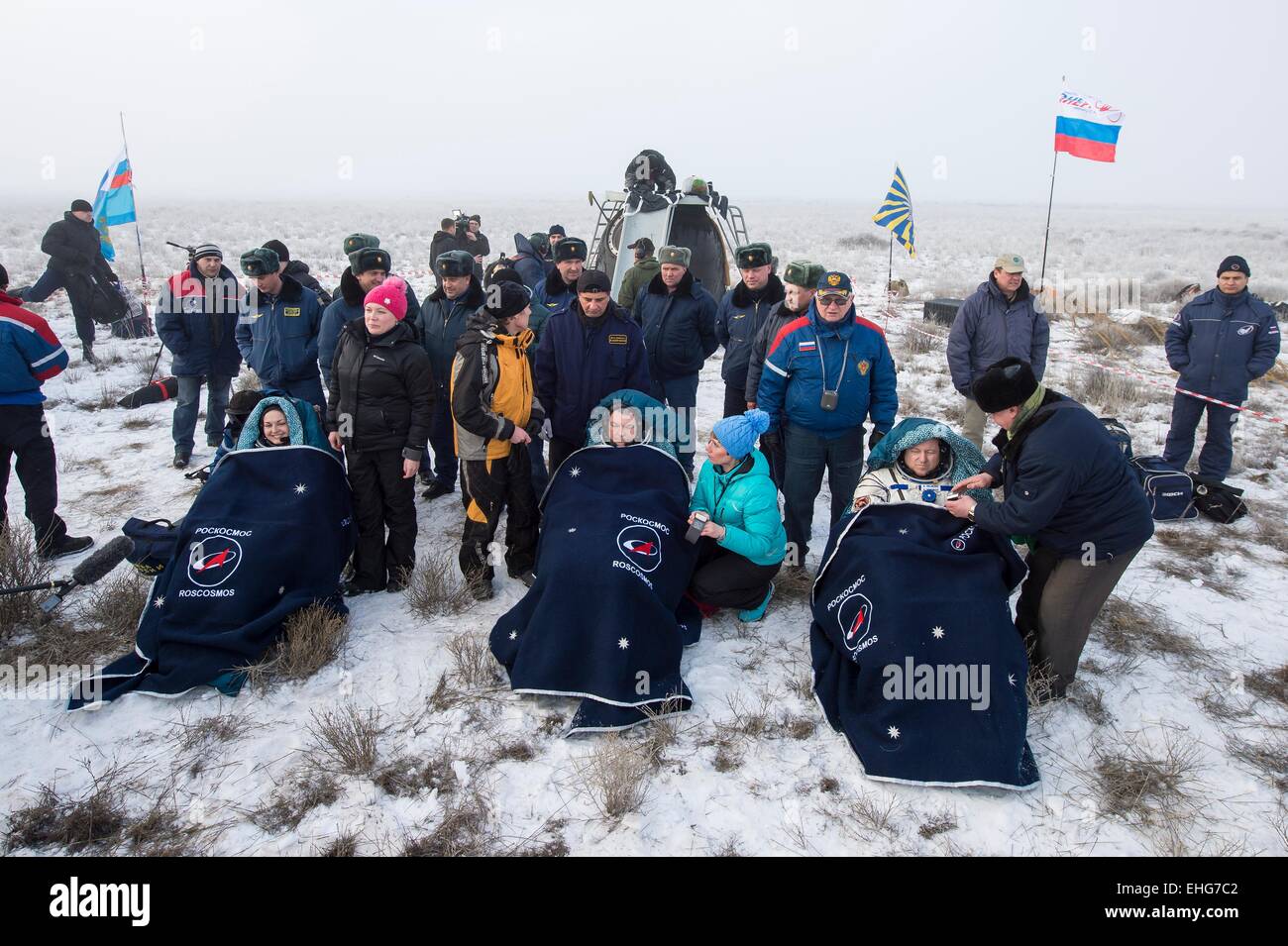 ISS Expedition 42 crew Russian Cosmonaut Elena Serova, left, Alexander Samokutyaev and NASA Astronaut Barry Wilmore sit in chairs outside the Soyuz TMA-14M  capsule just minutes after they landed in a remote area March 13, 20154 near Zhezkazgan, Kazakhstan. The crew is returning after almost six months onboard the International Space Station. Stock Photo