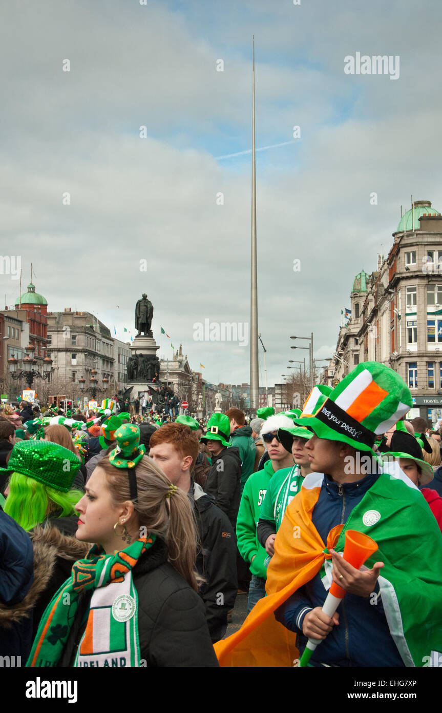 Festivalgoers attending the St Patrick's day parade in O'Connell Street Dublin Ireland with distinctive Dublin features behind Stock Photo
