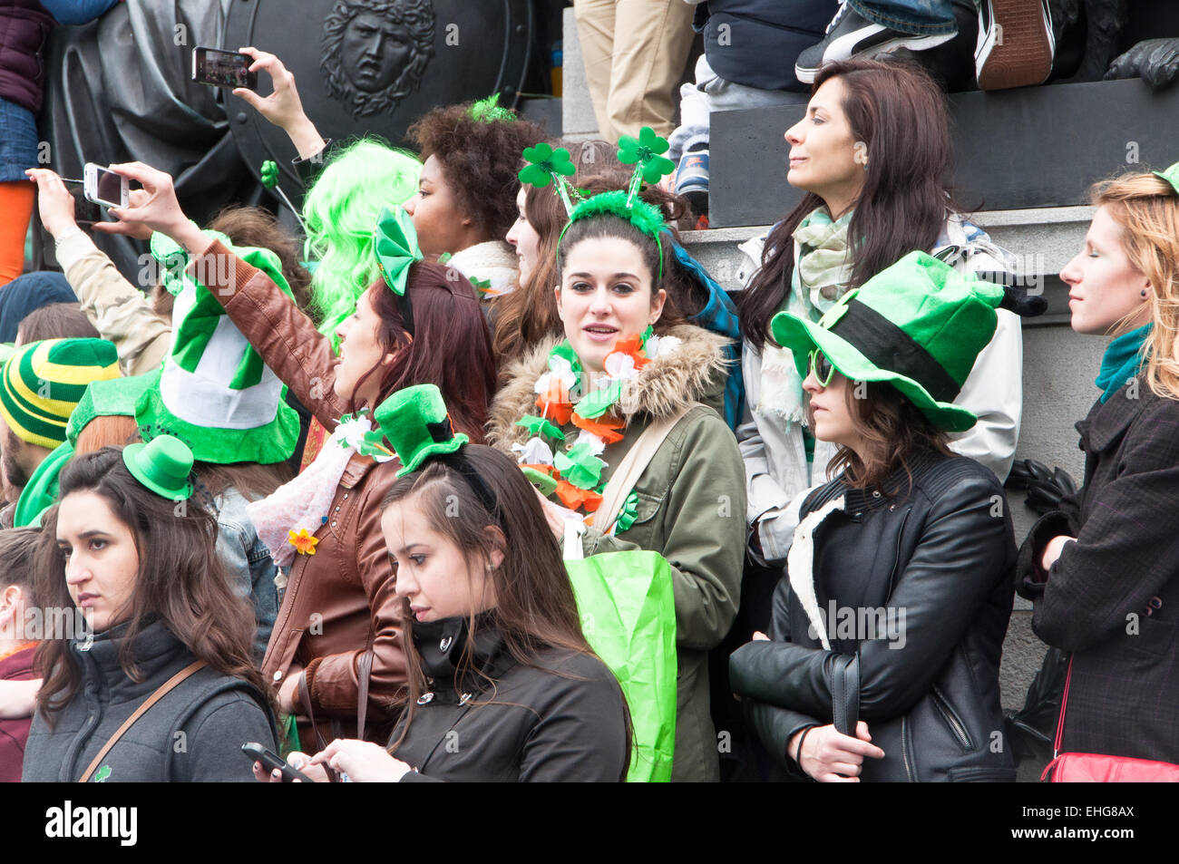 Girl in crowd attending the St Patrick's day festival in O'Connell Street Dublin Ireland wearing green rabbit's ears Stock Photo
